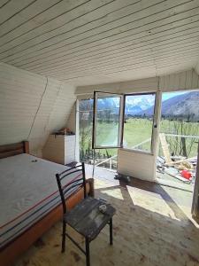 a bedroom with a bed and a chair and a window at Artani selimi in Valbonë