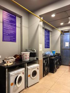 a laundry room with three washers and dryers at Studio apartment in Siroli