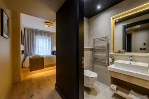 a bathroom with a sink and a toilet and a bed at The Gable, Dingle in Dingle
