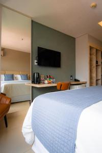 a bedroom with a bed and a tv on a wall at Uchôa Teresina Hotel in Teresina +60 photos