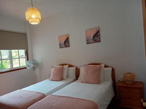 a bedroom with two beds with pink and white pillows at Vv - Casa Clary -Finca Medina in Alojera