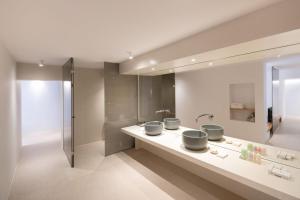 a bathroom with three sinks and a shower at Lilium Hotel Santorini in Fira +107 photos