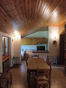 a kitchen with a wooden ceiling and a table and chairs at Carpineti Republic in Monterone