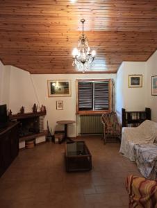 a living room with a wooden ceiling and a chandelier at Carpineti Republic in Monterone