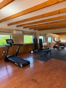 a gym with several exercise equipment in a room with wooden floors at Hotel Rural Quinta do Marco - Nature & Dining in Tavira