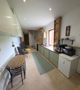 a kitchen and living room with a table and chairs at Hillside Home in Magyarhertelend