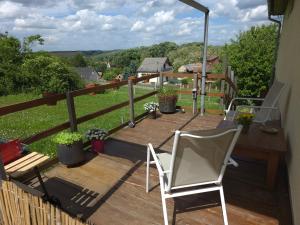 a wooden deck with two chairs and a table at Hillside Home in Magyarhertelend