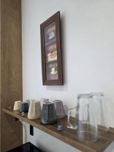 a wooden shelf with glasses and a picture on the wall at Hillside Home in Magyarhertelend