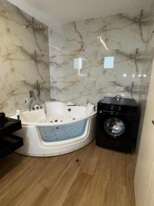 a bathroom with a tub and a washing machine at Villa Olivia Skioni in Nea Skioni +59 photos