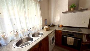 a kitchen with a sink and a washing machine at El Balcón de Gredos in Candeleda +45 photos