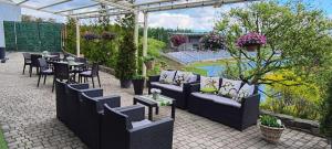 a patio with couches and a table and chairs at Hotel Forma in Piła