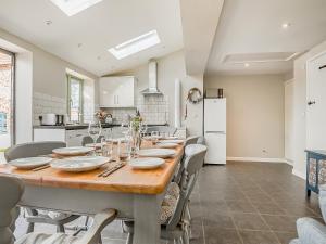 a kitchen with a large wooden table and chairs at Greenrush Cottage in Blakeney