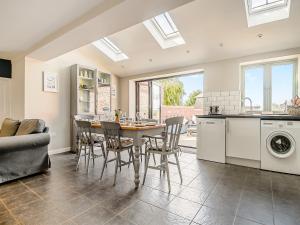a kitchen and dining room with a table and chairs at Greenrush Cottage in Blakeney