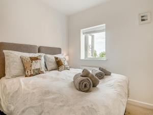 a white bed with towels on it in a bedroom at Greenrush Cottage in Blakeney +17 photos