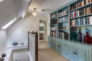 a home library with blue cabinets and bookshelves at Top Cottage, Oddington in Adlestrop