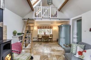 a living room with a staircase and a table at Top Cottage, Oddington in Adlestrop