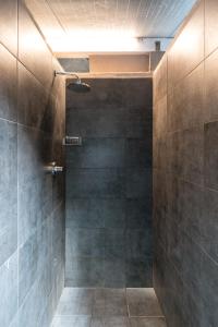 a bathroom with a shower with gray tiles at Camping Maremma Sans Souci in Castiglione della Pescaia +106 photos