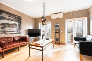 a living room with a couch and a table at Exquisite Townhouse in Lisbon City Center- PRIVATE GARAGE & TERRACE in Lisbon