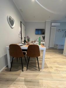 a dining room table with two chairs and a kitchen at Casa Ezio beach&relax in Chioggia