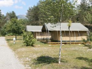 a building with a tent in the middle of a field at Camping Lou Passavous in Le Vernet