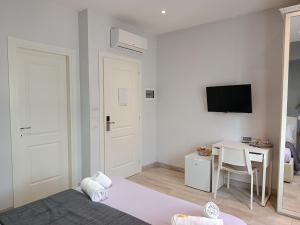 a bedroom with a bed and a desk and a television at B&B Purple Italy in Fiumicino