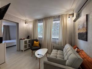 a living room with a couch and a chair at Sozopol Romance Apartments in Sozopol