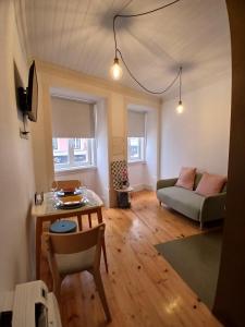 a living room with a couch and a table at Green View Studios Coimbra in Coimbra