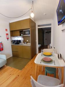 a living room with a table and a kitchen at Green View Studios Coimbra in Coimbra