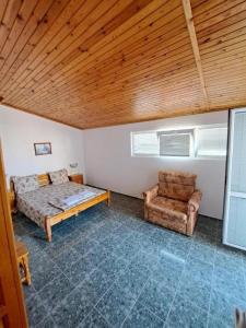 a bedroom with a bed and a chair in it at Capri Family Hotel in Primorsko