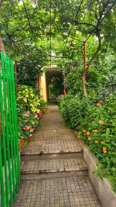 a wooden pathway with a green fence and flowers at Capri Family Hotel in Primorsko