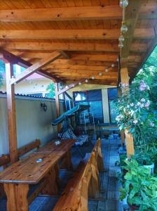 a porch with a wooden bench and a wooden roof at Capri Family Hotel in Primorsko