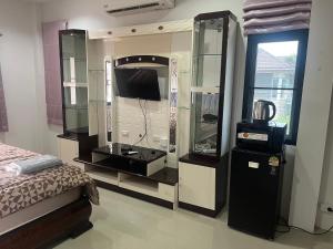 a bedroom with a bed and a tv and a mirror at Baansuan Runjuan Suratthani บ้านสวนรัญจวนสุราษฎร์ธานี in Ban Huai Chiat +86 photos