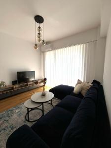 a living room with a blue couch and a table at Hug and Fly Apartment in Skopje