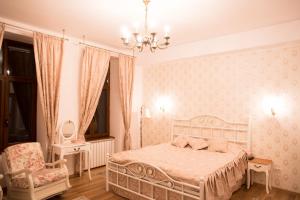 a bedroom with a bed and a chair and a chandelier at Elegance Residence in Timişoara