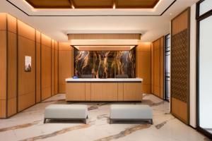 a lobby with a reception desk and two stools at Oakwood Yogyakarta in Yogyakarta +37 photos