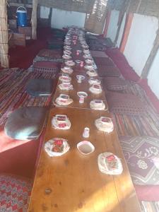 a long wooden table with plates and dishes on it at safari book in Bawati