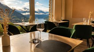 a restaurant with a table with wine glasses and a view at Essentia Guest House in Faggeto Lario 