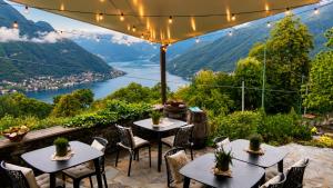 a patio with tables and chairs and a view of a river at Essentia Guest House in Faggeto Lario 