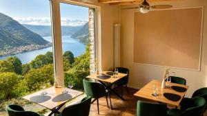 a restaurant with tables and chairs and a large window at Essentia Guest House in Faggeto Lario 