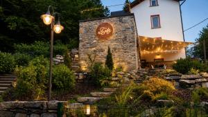 a garden with a stone building with lights on it at Essentia Guest House in Faggeto Lario 
