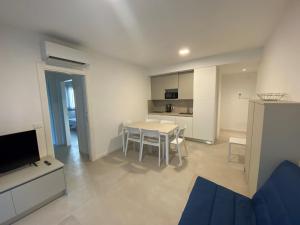 a living room with a dining room table and a kitchen at Cozy flat 300m from the beach in Bibione