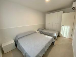 a bedroom with two beds and cabinets in it at Cozy flat 300m from the beach in Bibione