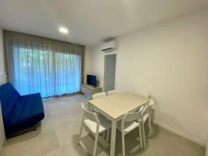 a dining room with a table and a blue chair at Cozy flat 300m from the beach in Bibione