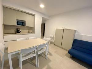 a dining room with a table and a blue couch at Cozy flat 300m from the beach in Bibione +13 photos