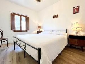 a bedroom with a large white bed and a chair at Locanda dei Gelsomini in Civitella Del Lago