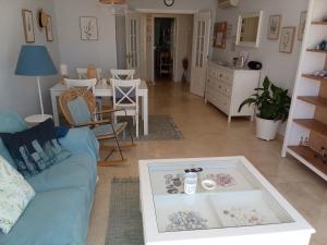 a living room with a blue couch and a table at Elviria Beauty by the sea in Marbella