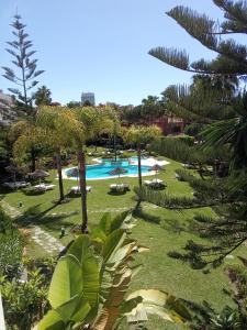 a view of a resort with a pool and trees at Elviria Beauty by the sea in Marbella