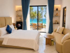 a bedroom with a bed and a view of the ocean at Resort Hoa Loi in Vĩnh Cửu Lỏi (1)