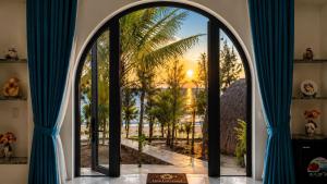 an arched window in a room with blue curtains at Resort Hoa Loi in Vĩnh Cửu Lỏi (1) +65 photos