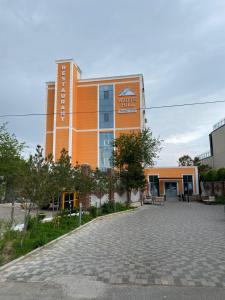 an orange building with a driveway in front of it at Boutique Hotel "White HiLL" in Aktau +15 photos